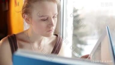 女孩在窗户边看书，用自然光和反射器把肖像关上